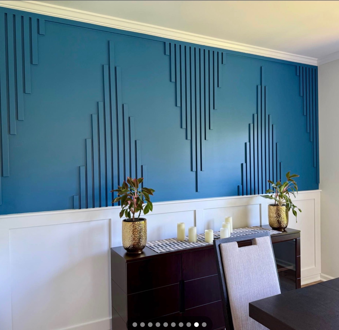 Blue accent wall with geometric vertical panel design in dining room